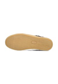 Semelle de chaussure en caoutchouc avec un motif texturé ; couleur brun clair ; forme arrondie ; design à adhérence secure avec un logo ovale au centre.