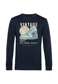 Felpa navy con maniche lunghe, caratterizzata da una grafica di una sneaker vintage e testo in vari colori e font. Morbido tessuto di cotone.