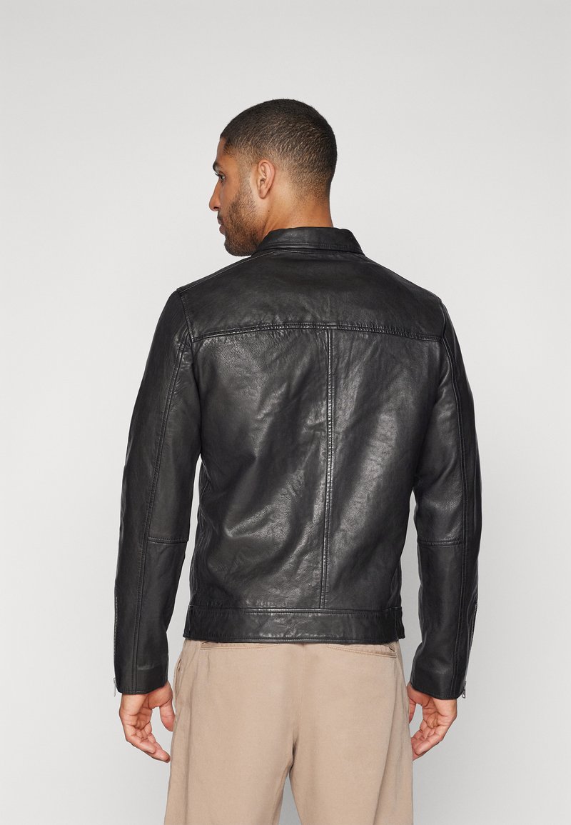 Schwarze Lederjacke mit tailliertem Design, flachem Kragen und sichtbaren Nähten. Verfügt über Reißverschlussärmel und eine glatte Textur.