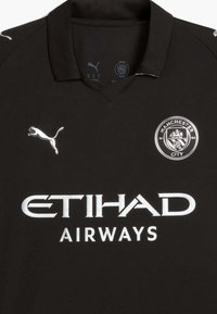 Svart Manchester City fotbollströja i ventilerande tyg. Har en polo-krage, vit logotyp och text, med silverdetaljer på axlarna.