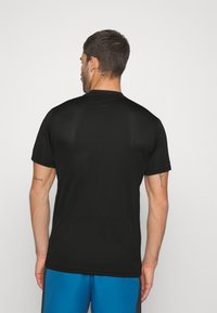 Camiseta atlética negra con cuello redondo y mangas cortas. Hecha de una tela suave y transpirable, con un diseño ajustado.