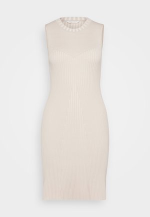 Knit sleeveless dress in soft beige with vertical ribbing, fitted silhouette, and a crew neckline. Smooth texture with subtle shaping details.