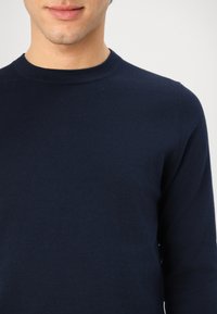 Marineblauer Rundhalsausschnitt-Pullover aus weichem, leichtem Stoff. Verfügt über lange Ärmel und eine glatte, gleichmäßige Textur ohne sichtbare Muster.