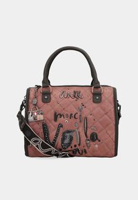 Borsa a tracolla trapuntata rosa con manici neri, charms decorativi e scritte "merci" e "Anekke", dotata di una fascia per spalla nera con motivo.