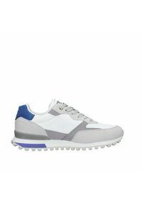Scarpa sportiva bianca e grigia con tessuto testurizzato, dettagli in sovrapposizione e un tallone blu. Presenta una suola robusta con dettagli viola.