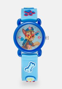 Relógio de silicone azul com mostrador redondo apresentando um cão de desenho animado. Acentos coloridos de impressões de patas e ossos. Pontas das horas e minutos em vermelho, marcadores das horas numerados.