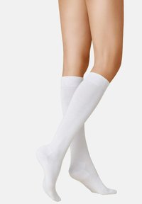 Kniehohe, weiße Socken aus einem glatten, elastischen Material mit gerippten Bündchen, die ein sauberes, minimalistisches Design hervorheben.