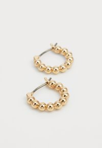 Χρυσές σκουλαρίκια σε σχήμα κρίκου με μια σειρά από λαμπερούς σφαιρικούς κόκκους, συνδεδεμένα με έναν λεπτό μεταλλικό κούμπωμα.