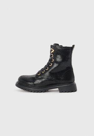 Black textured leather combat boot with gold eyelets, thick rubber sole, and pull tab, shown in side profile on a light background.