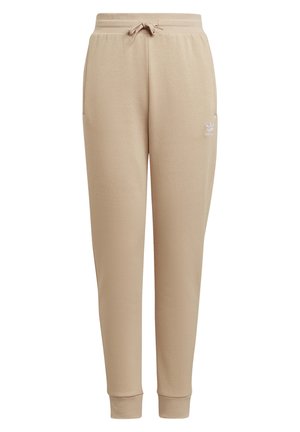 Beżowe zwężane spodnie dresowe z elastycznym pasem, sznurkiem do regulacji, bocznymi kieszeniami, ściągaczami na kostkach oraz małym białym logo Adidas na lewej udzie.