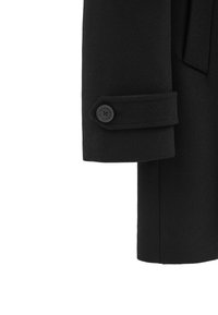 Svart ullkappa med ärm som har en jämn textur, knappstängning och en strukturerad design. Manschetten har en fälldetalj.