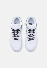 Scarpe da ginnastica bianche con accenti neri, parte superiore in mesh, superficie texturizzata e lacci piatti. Presentano un dettaglio del logo sulla linguetta e sui lati.