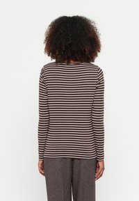 Braun-weißer gestreifter Langarmshirt mit Rundhalsausschnitt und taillierter Passform, kombiniert mit strukturierten grauen Culottes.