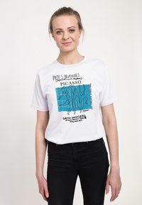 Bílý bavlněný tričko s modrým abstraktním vzorem, liniovou grafikou a potiskem textu, krátké rukávy a klasický kulatý výstřih.