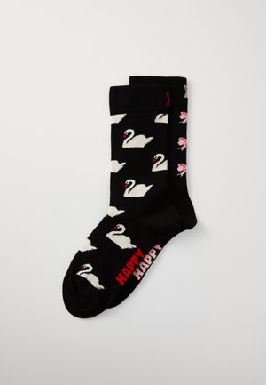 Black socks with a repeated white swan pattern and red accents. Features a solid black cuff and the text "HAPPY" in pink on the sole.
