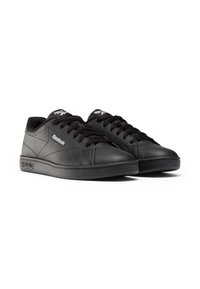 Zapatillas de cuero negro con perfil bajo, punta redonda, superficie texturizada y cordones negros. Presentan un logo en el costado y en la lengüeta.