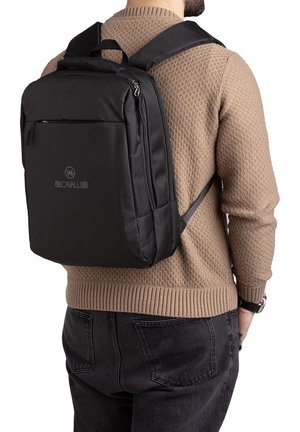 Zaino in nylon nero con spallacci regolabili, tasca anteriore con zip e schienale imbottito. Presenta una texture liscia e un logo sul pannello anteriore.