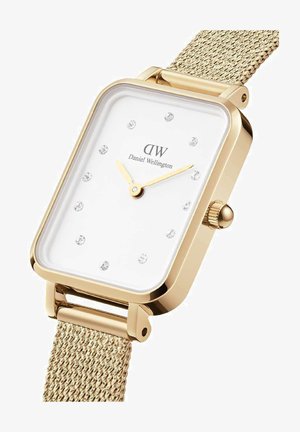 Guld rektangulär klocka med vit urtavla, kristalltimmarkörer och ett mesharmband. Har en krona på sidan för justering av tiden.