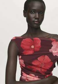 Top ajusté à épaules dénudées de couleur bourgogne foncé avec un grand motif floral rouge et rose. Tissu lisse et extensible avec de subtils détails plissés.