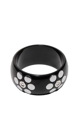 Bracciale rigido largo nero con due motivi floreali composti ciascuno da sette borchie circolari d'argento.