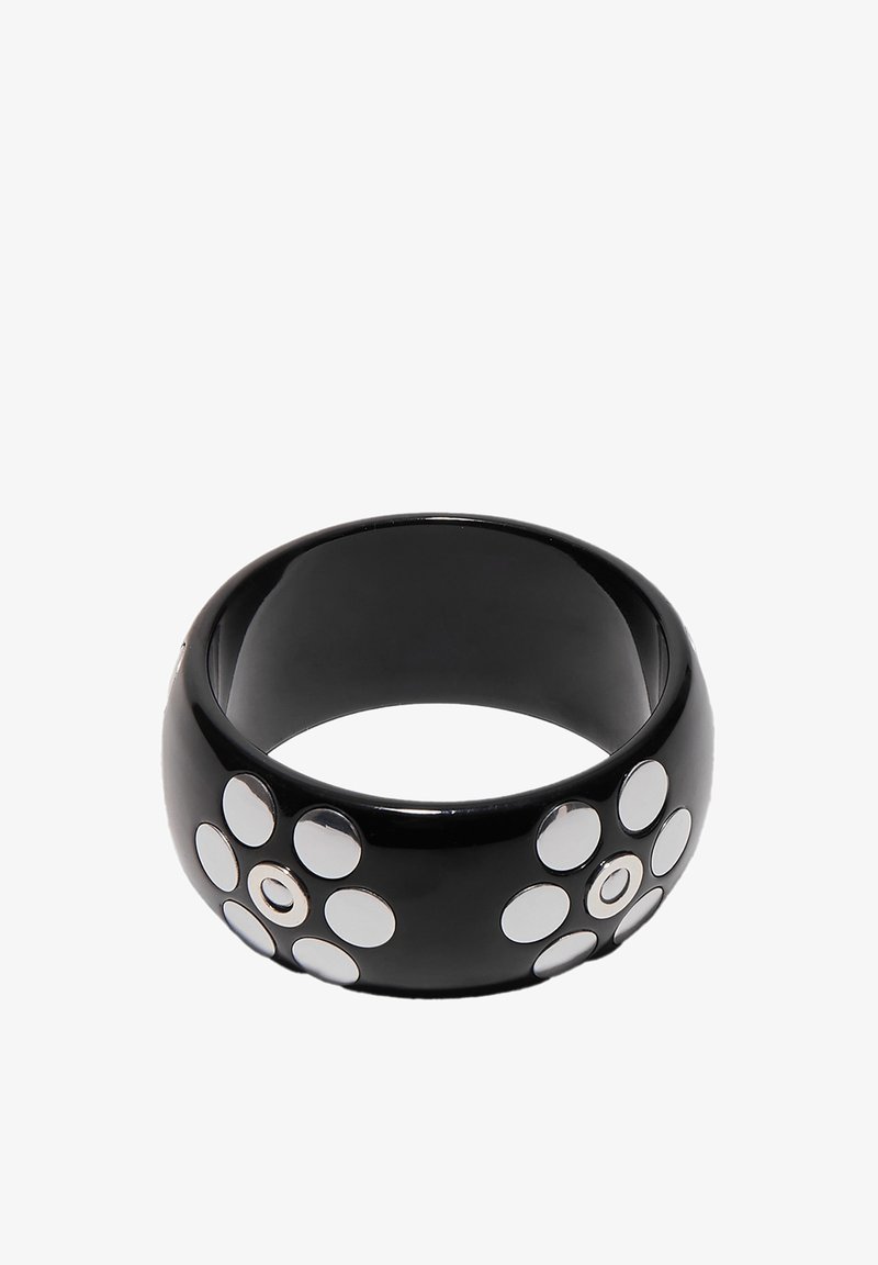 Large bracelet jonc noir avec deux motifs floraux composés chacun de sept clous circulaires en argent.