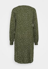 Robe à manches longues vert olive avec motif de points blancs irréguliers, coupe ample et encolure ronde, vue de dos.