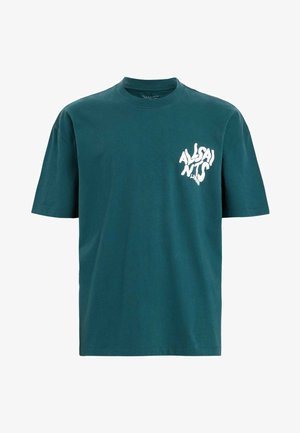 Teal katoenen t-shirt met korte mouwen, ronde hals en witte grafische tekst aan de linkerkant. Zachte textuur, ontspannen pasvorm, minimalistisch ontwerp.