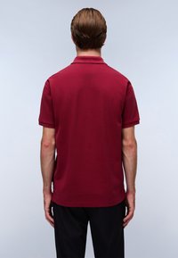 Polo shirt bordeaux, maniche corte, design con colletto, materiale in cotone, texture liscia, vista posteriore, abbinato a pantaloni neri.