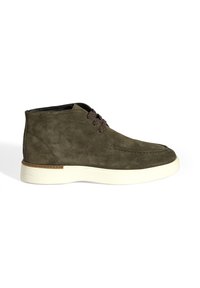 Groene suède enkelboots met een ronde neus, twee bruine veters en een witte rubberen zool met een lichte textuur.