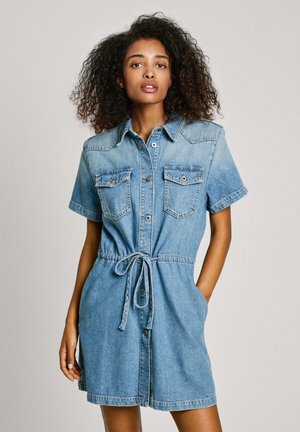 Robe en jean bleu clair avec manches courtes, bouton sur le devant, col, deux poches poitrine et détail de taille nouée. Texture lisse avec une coupe décontractée.