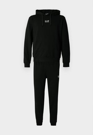 Czarny komplet bluzy i spodni dresowych wykonany z bawełny, z kapturem, elastycznymi ściągaczami oraz logo na klatce piersiowej i nogawce. Gładka faktura.