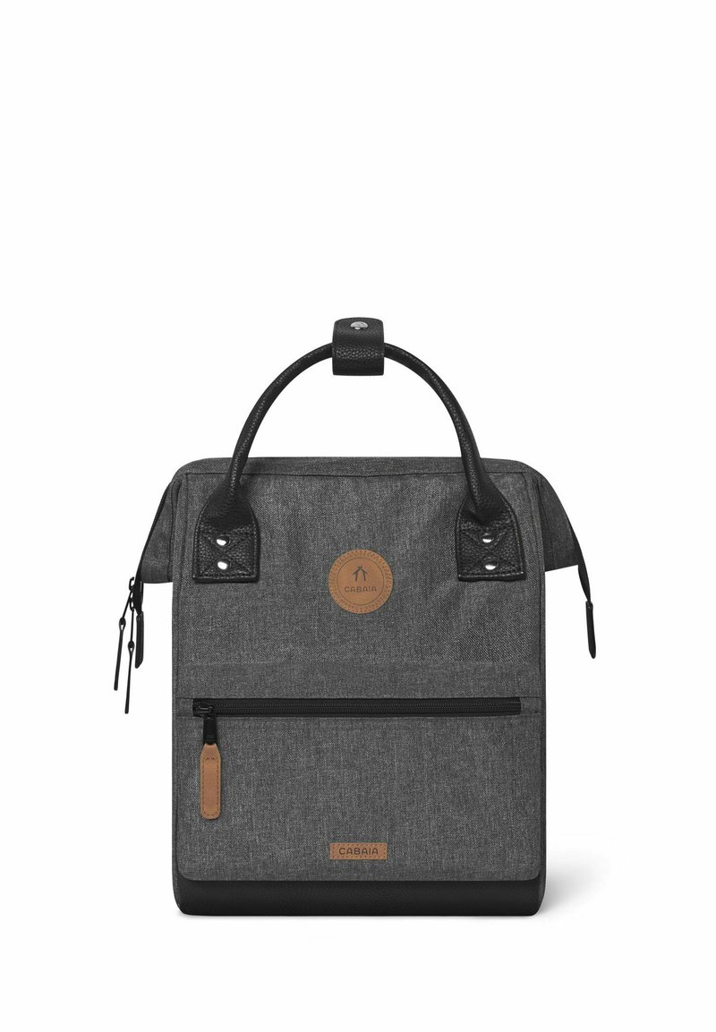 Gray fabric backpack with black leather accents, round logo patch, top handle, front zip pocket, and two side pockets. Rectangular shape.