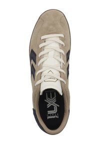 Beige Wildleder-Sneaker mit schwarzen Akzenten, runder Zehenpartie und weißen Schnürsenkeln. Enthält Logo auf der Innensohle und eine strukturierte Gummisohle.