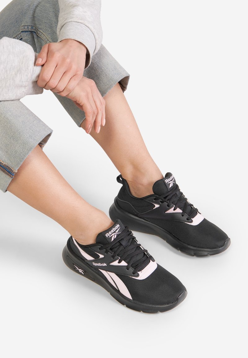 Czarne buty sportowe z różowymi akcentami, siateczkowa cholewka i amortyzowana podeszwa. Sznurowadła są czarne; logo wyświetlone na języku i z boku.