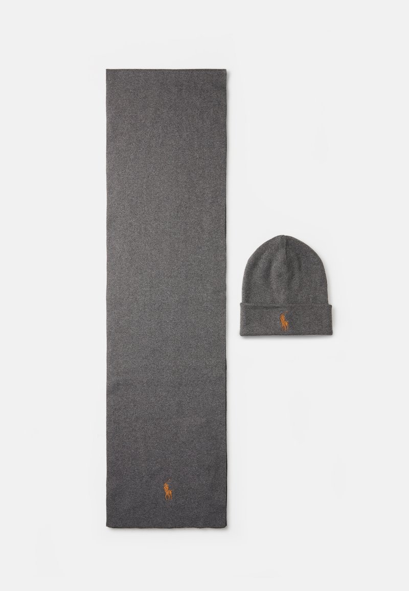 Conjunto de cachecol de malha cinza e gorro correspondente. O cachecol é longo e retangular, e o gorro possui uma volta. Ambos apresentam um logótipo bordado em laranja.