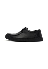 Zwarte leren schoen met een gestructureerd oppervlak, ronde neus en vetersluitingen. Beschikt over een dikke rubberen zool en minimalistische accenten.