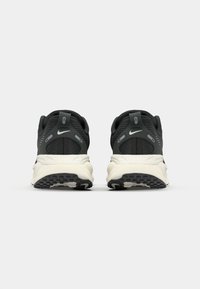 Schwarze und graue Sportschuhe mit einem Obermaterial aus Mesh, gepolsterter weißer Zwischensohle und strukturiertem schwarzen Gummiaußensohle; mit einem auffälligen Logo.