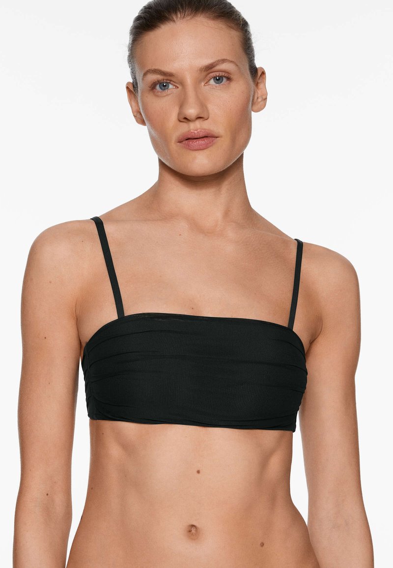 Top bandeau negro con tirantes finos, que presenta plisados horizontales y una textura suave. Diseñado para un aspecto ajustado y minimalista.