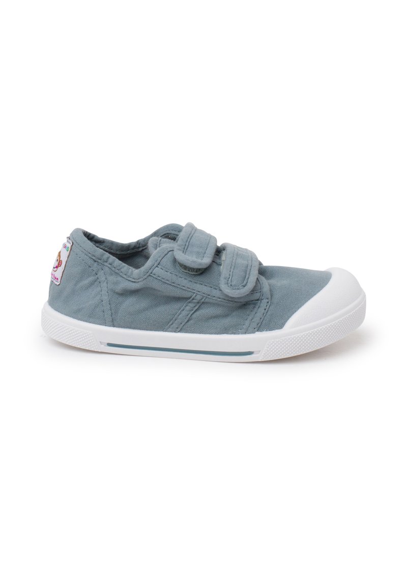 Baskets pour enfants bleu clair avec semelle blanche et deux bandes Velcro, ornées d'un patch d'animal ludique sur le côté.