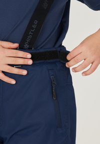 Marinblå byxor med justerbara bälten, utrustade med kardborrestängning och dragkedjeficka på sidan, tillverkade av ett slätt och hållbart tyg.