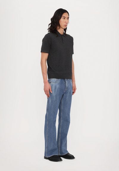 Charcoalová polokošeľa s krátkym rukávom a golierom, skombinovaná s svetlomodrými rozšírenými džínami. Nosené s čiernymi topánkami. Jednoduchý dizajn, čísté línie.