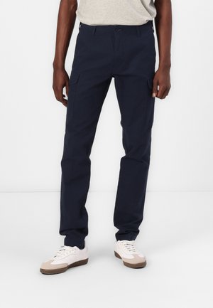 Navy blue cargo pants made of cotton blend, featuring multiple pockets, a flat front, and a straight-leg design. Worn with white sneakers.