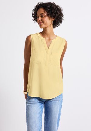 Débardeur jaune sans manches avec un décolleté en V et deux poches avant, fabriqué à partir d'un tissu léger, texture lisse et ourlet arrondi.