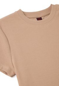T-shirt beige côtelé à manches courtes avec col rond et coutures visibles autour du col et des bords des manches.