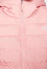 Veste rose gonflante avec capuche, dotée d'une fermeture éclair centrale, d'un design matelassé et d'un logo imprimé en blanc en bas à droite à l'avant.