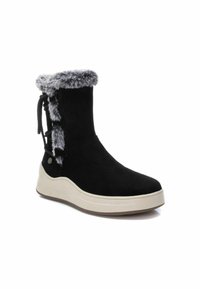 Stivale in suede nero con colletto in fogna e dettagli in nastro ai lati; presenta una suola bianca spessa e un design della punta arrotondata.