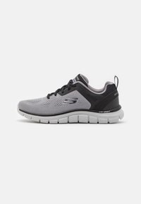 Gray and black athletic shoe with mesh upper, lace closure, lightweight cushioning, and textured sole for traction.