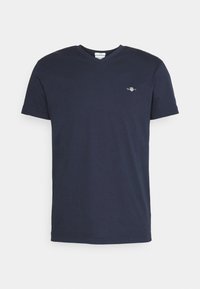 T-shirt bleu marine en coton à manches courtes et col en V avec un petit logo brodé blanc et rouge sur la poitrine gauche.