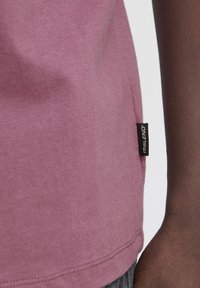 Kortærmet, tætsiddende T-shirt i mauve bomuld, med et side søm label med brandnavn, glat tekstur og simpel kant.