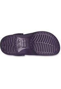 Lila Gummisohle von Crocs mit ausgeprägten Profilmustern, einschließlich Rillen und Vertiefungen für besseren Halt. Mit Logos und Größenmarkierungen.